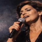 Linda de Suza a cantar com emoção no palco